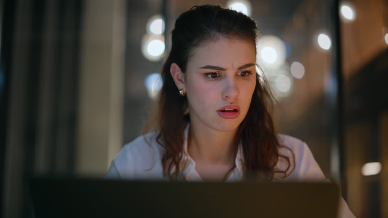 Woman concerned software error looking laptop at dark business office closeup