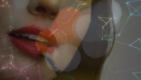 animation of network of connections and light spots over caucasian woman painting lips