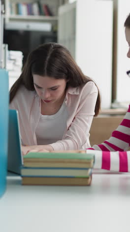 students group searches online sources in library. concentrated young people work on laptop upon educative project in reading hall. e-learning technology