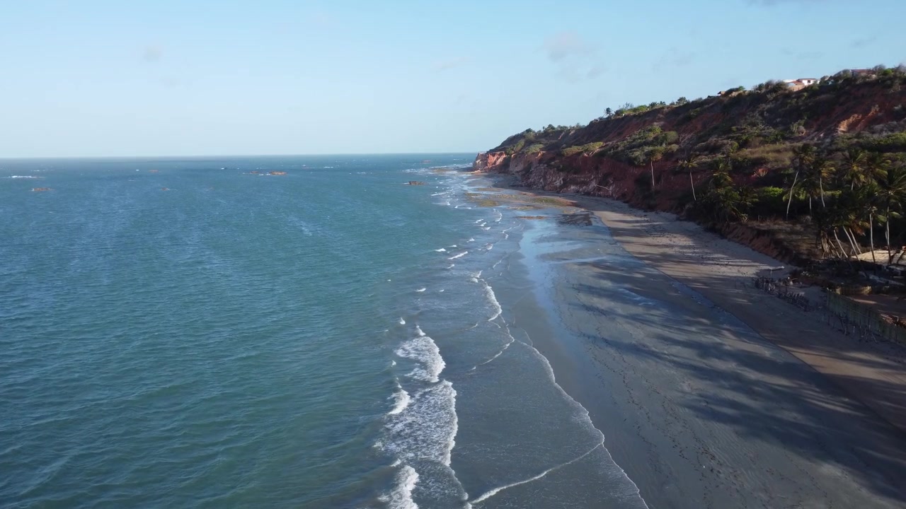 Drone avançando em uma bela praia deserta com ondas calmas no nordeste do Brasil