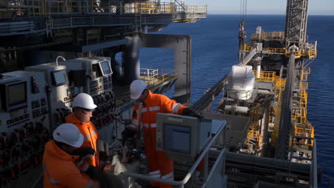 workers operating machinery on an offshore oil rig