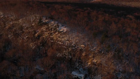 Drohne-Fliegt-Bei-Sonnenaufgang-Zum-Verschneiten-Bergrückenwald