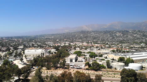 aerial shot flying over the city buildings and luxury homes with mountains in the distance in downtown santa barbara