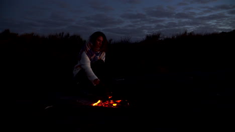 Young-girl-alone-in-dark-woods-alone-by-campfire