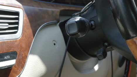 close-up of steering wheel area in luxury car with focus on control lever and trim