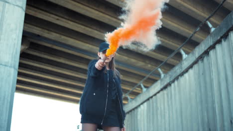 Girl-in-cap-protesting-on-street-with-smoke-bomb.-Woman-holding-smoke-grenade