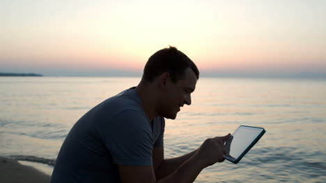 Mann-Benutzt-Tablet-Computer-Am-Strand