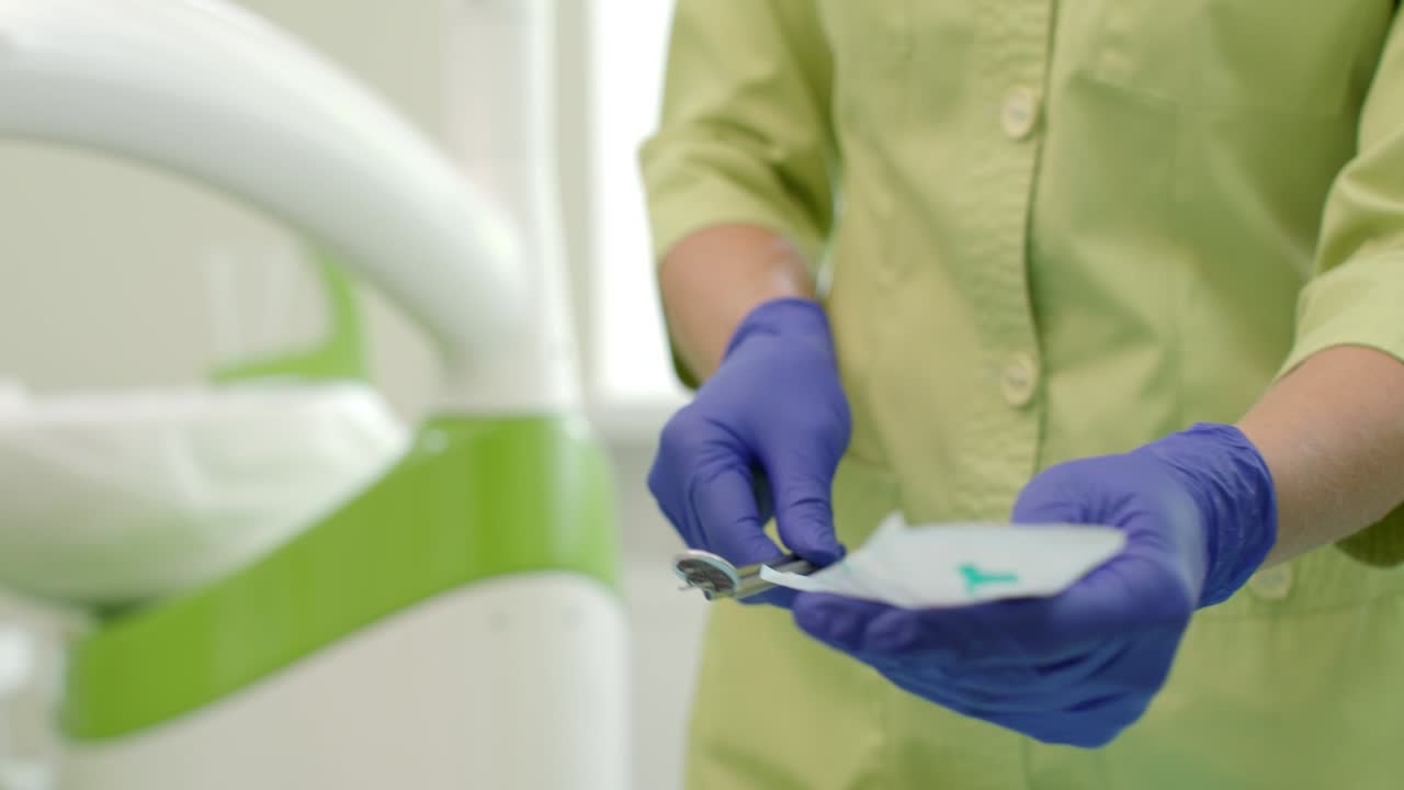 stomatólogo preparando espejo dental y sonda. cerrar las manos de la mujer