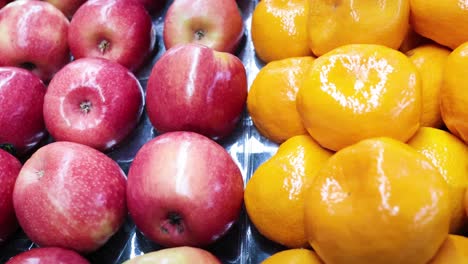 apples and oranges neatly arranged in supermarket