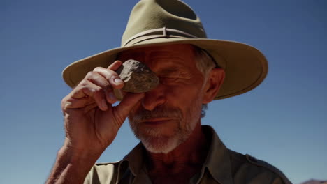 senior explorer examining a stone artifact
