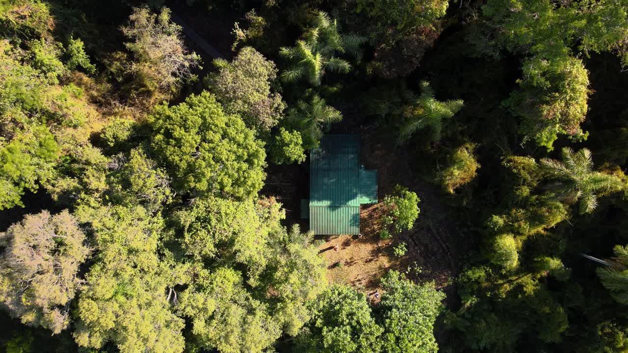 drone de arriba hacia abajo disparado volando hacia arriba de una pequeña cabaña en la selva tropical de misiones, argentina