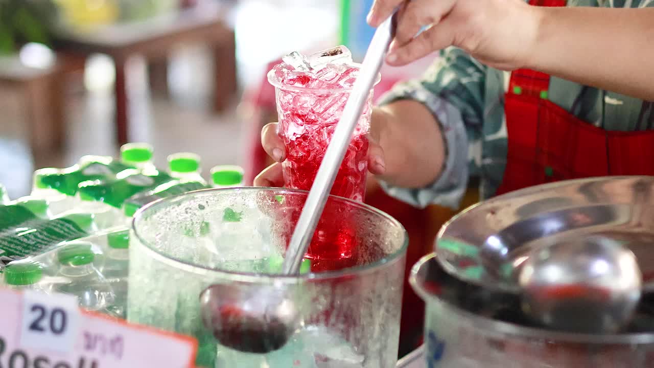 el vendedor sirve una refrescante bebida de rosella con hielo.