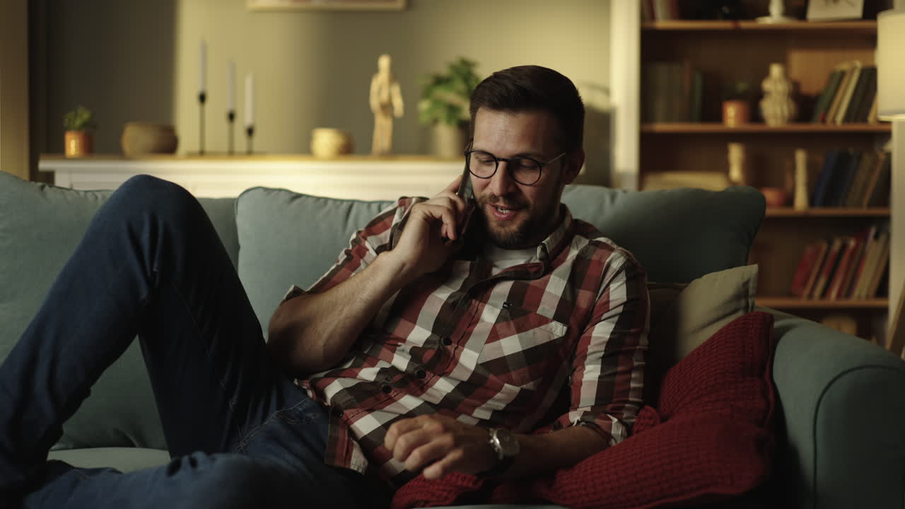 Man Relaxing on Couch While Talking on Phone
