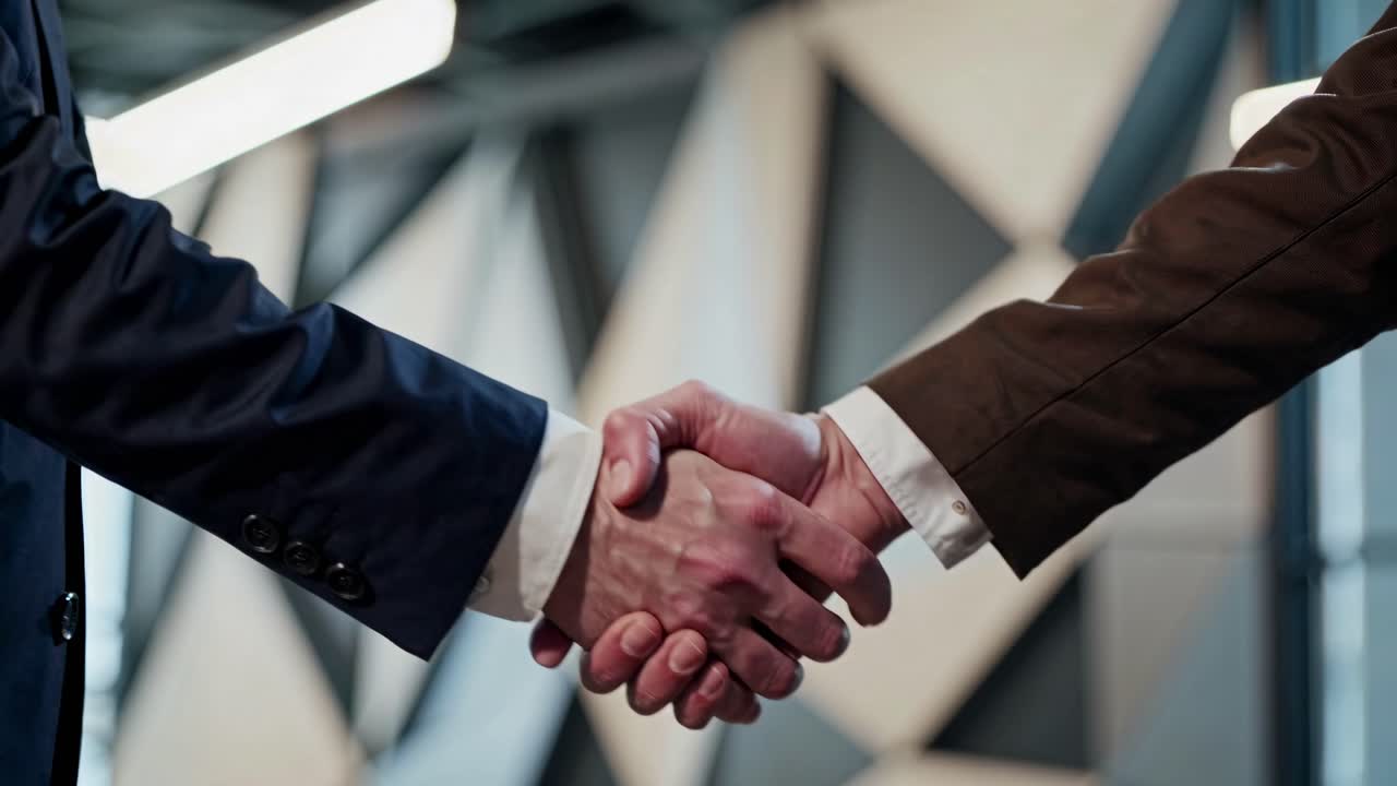 Two people shaking hands in a business setting. Close-up of a handshake, symbolizing agreement