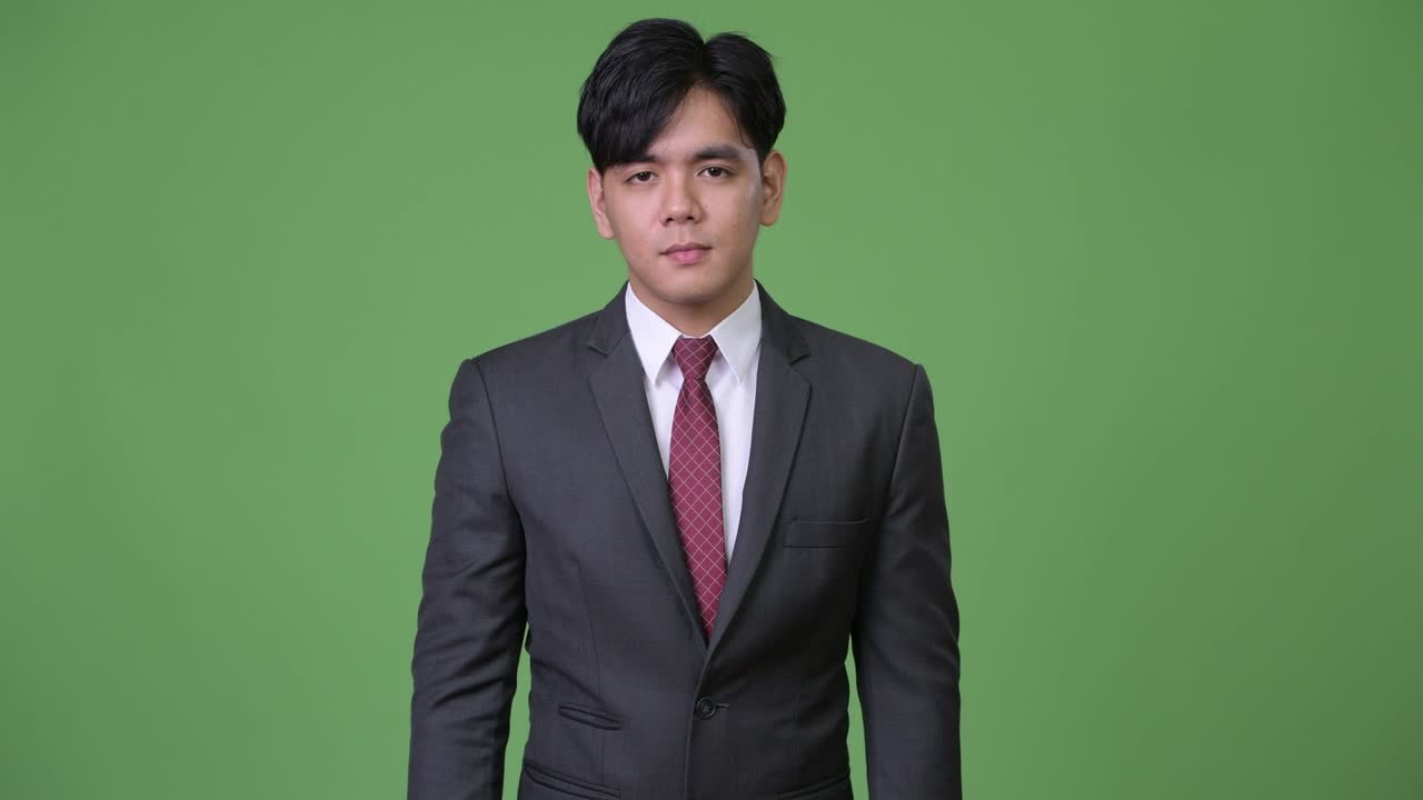 젊은 잘생긴 아시아 사업가가가 멈추기 위해 몸짓을 하고 있다.