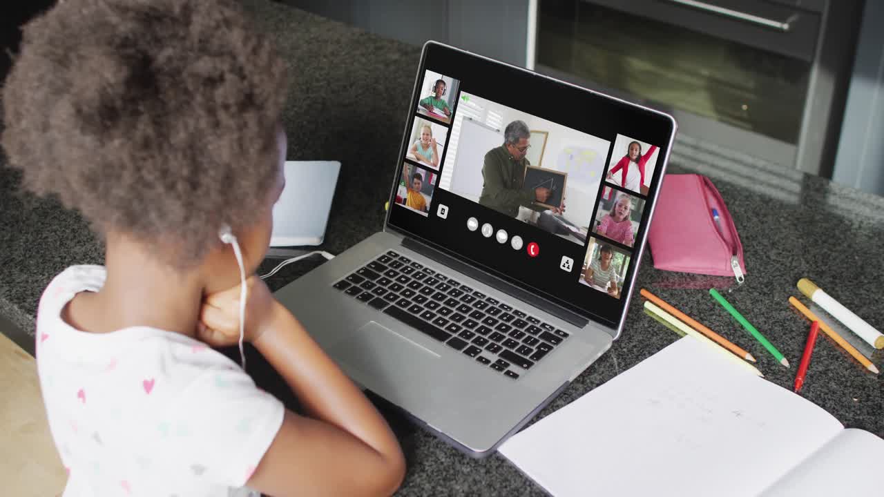 African american girl using laptop for video call with male teacher and class on screen