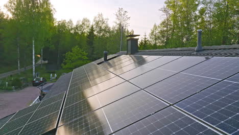 aerial: sunset sky mirroring from solar cell surface on a rooftop, summer evening