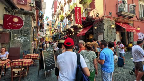 calle llena de gente cerca de un café