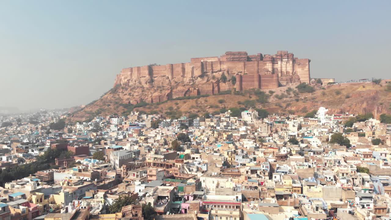 paisaje azul de la ciudad de jodhpur que rodea el fuerte de mehrangarh sobre un acantilado en rajasthan, india - toma aérea revelada