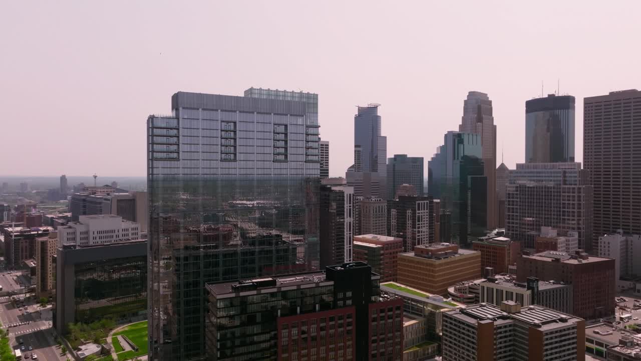 una captura cautivadora de un dron de un edificio de vidrio icónico en el centro de minneapolis, enmarcado contra el impresionante horizonte de la ciudad