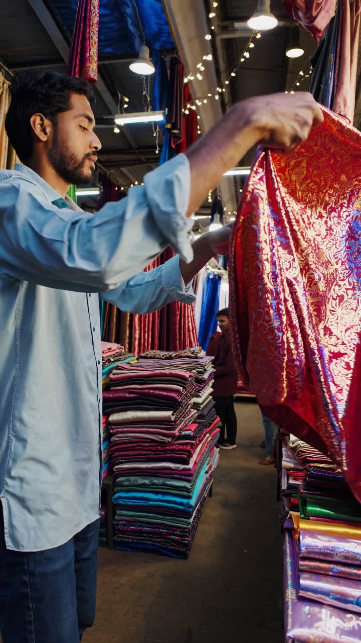 A vibrant textile market captured from a low angle, showcasing colorful fabrics and bustling