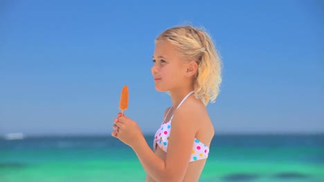 little blonde girl eating a water ice