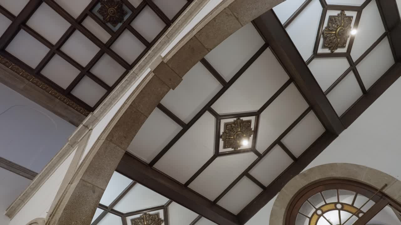 Soffitto interno di una chiesa che mostra archi, travi e luci decorative luminose