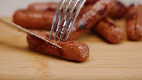 sharp knife slices through cooked breakfast sausage in slow motion