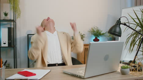 business woman winner working browsing typing on laptop at office celebrate lottery win good news