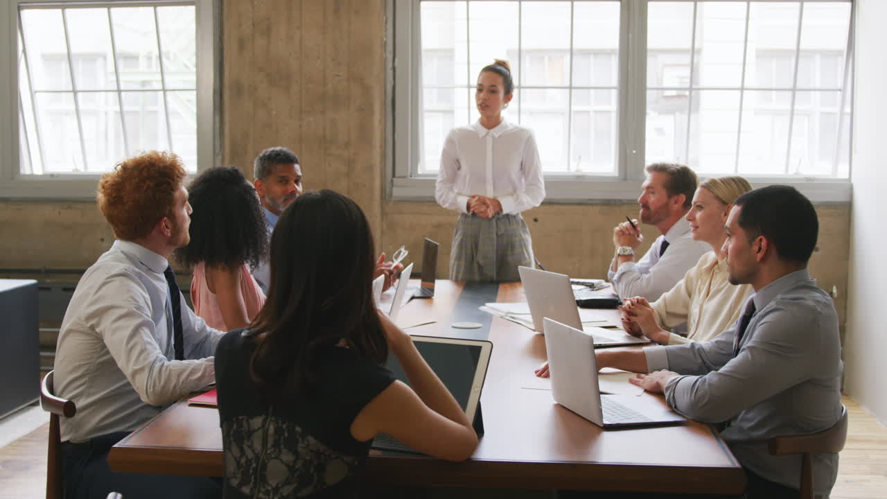 jefa femenina dirigiendo una reunión con colegas en una sala de juntas
