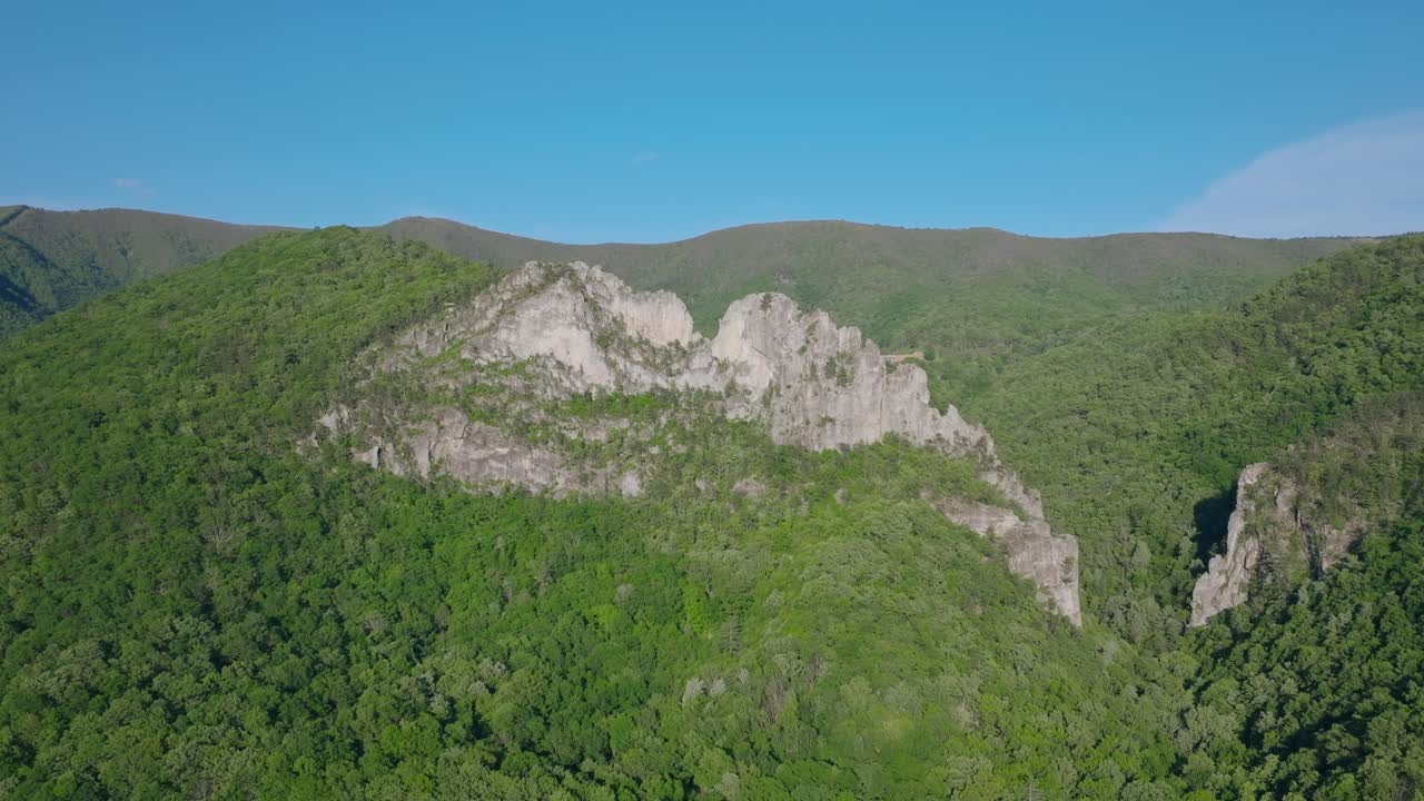Inquadratura aerea media della cresta di Seneca Rocks che si erge sopra la fitta foresta degli Appalachi in West Virginia, ripresa dal basso verso l'alto e dall'alto verso il basso
