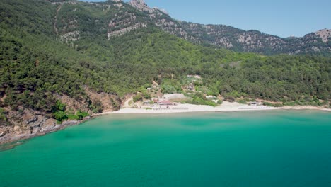 drone view of paradise beach, surrounded by green vegetation and high mountain peaks with tropical turquoise water, thassos island, greece, mediterranean sea, europe