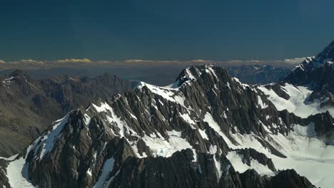 Snow-capped-rocky-mountains-in-Aoraki-Mountain-Cook-National-Park,-Southern-Alps,-New-Zealand-from-airplane-scenic-flight-with-glacier-Lake-Pukaki-in-background