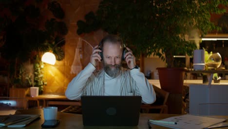 man working on laptop at home at night