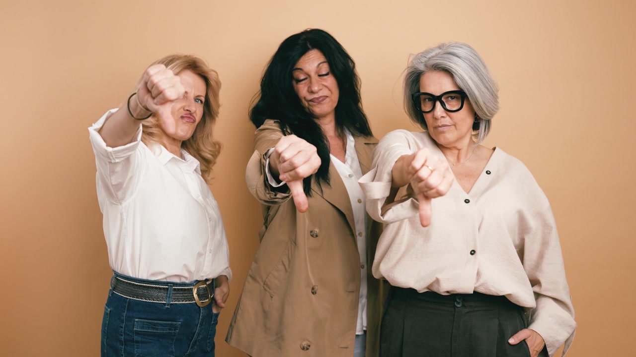 Three Mature Women Giving Thumbs Down Gesture