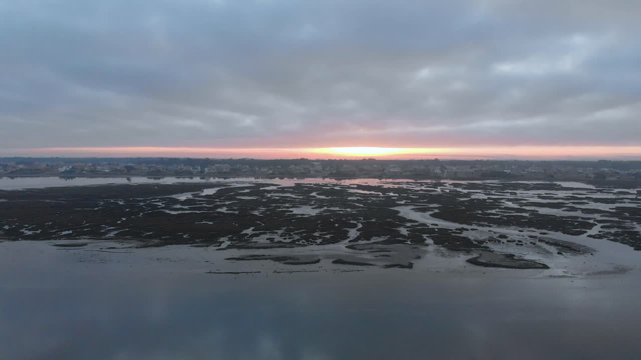 vista aérea durante el amanecer de un pequeño pueblo en una reserva natural y su río