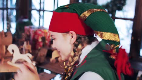 joyful emotions of an elf girl. the girl at the table with new year's toys opens christmas letters to santa claus