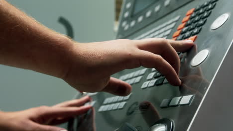 close up of hands of worker setting parameters for a cnc production in a factory