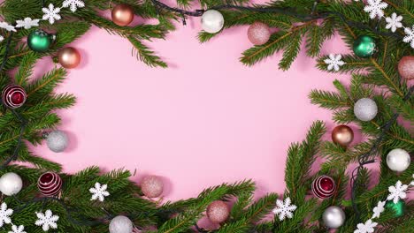 luces parpadeantes en el marco de navidad con adornos de pino y adornos en tema rosa pastel.