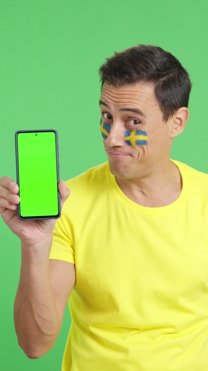 Swedish supporter looking at his mobile smiling and showing it