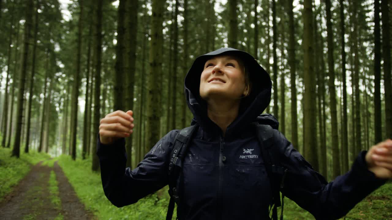 비가 내리는 숲에서 산책하는 행복한 여성, 숲에서 깊은 숨을 들이마시며, 세상과 연결을 끊고 숲에서 걸어다니는 행복한 여성.