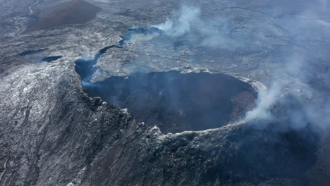 Vista-Aérea-En-El-Cráter-Del-Volcán-Después-De-La-Erupción.-Laderas-De-Montaña-Cubiertas-Con-Una-Capa-Gris-Brillante-De-Lava-Emitida-Por-Enfriamiento.-Volcán-Fagradalsfjall.-Islandia,-2021