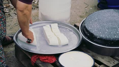 the old woman is making homemade cheese using traditional methods.