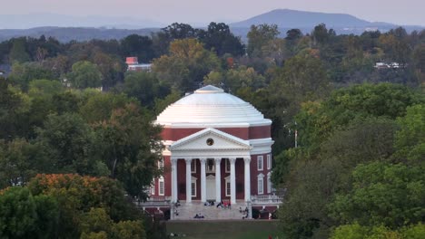 the rotunda building in usa with relaxing students in park area. university of virginia during autumn season. aerial approaching shot.