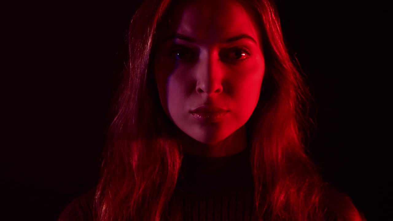 Woman face in strobe light. Domestic violance and home abuse victim