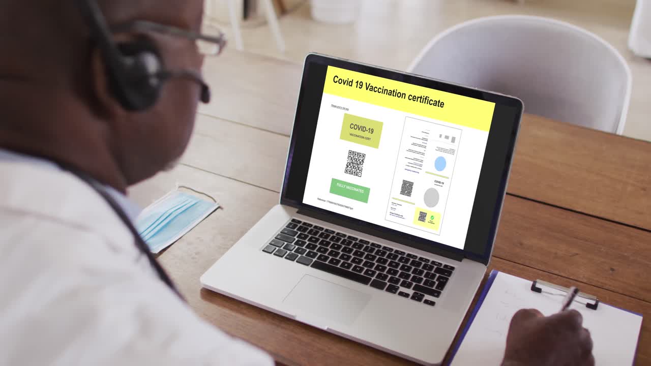 Man working at desk, covid vaccination certificate with qr code on laptop screen