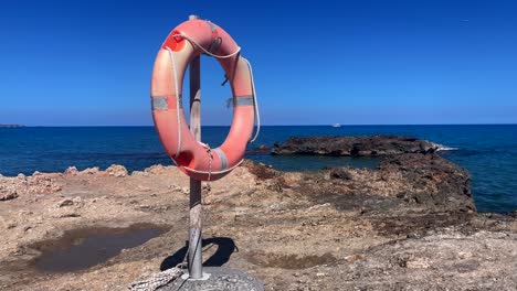 red life buoy on rocky coastline
