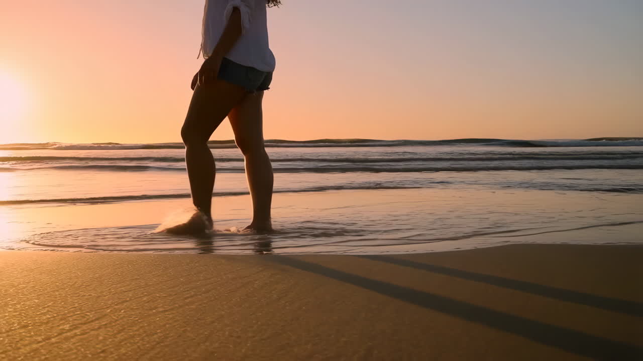 Person Walking on Beach at Sunset