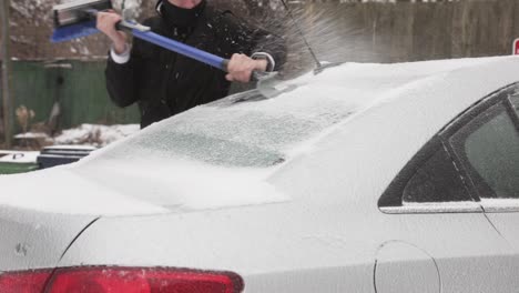 Un-Hombre-Raspando-A-La-Fuerza-La-Escarcha-De-Hielo-Formada-En-El-Parabrisas-Trasero-De-Su-Camión---Primer-Plano