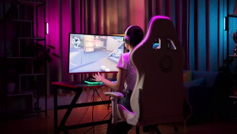 una adolescente asiática pierde mientras juega videojuegos en la computadora, videojuegos de disparos en línea